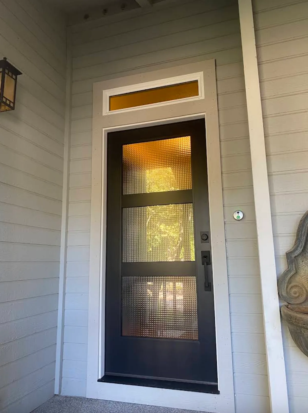 Black glass entry door installed at a home